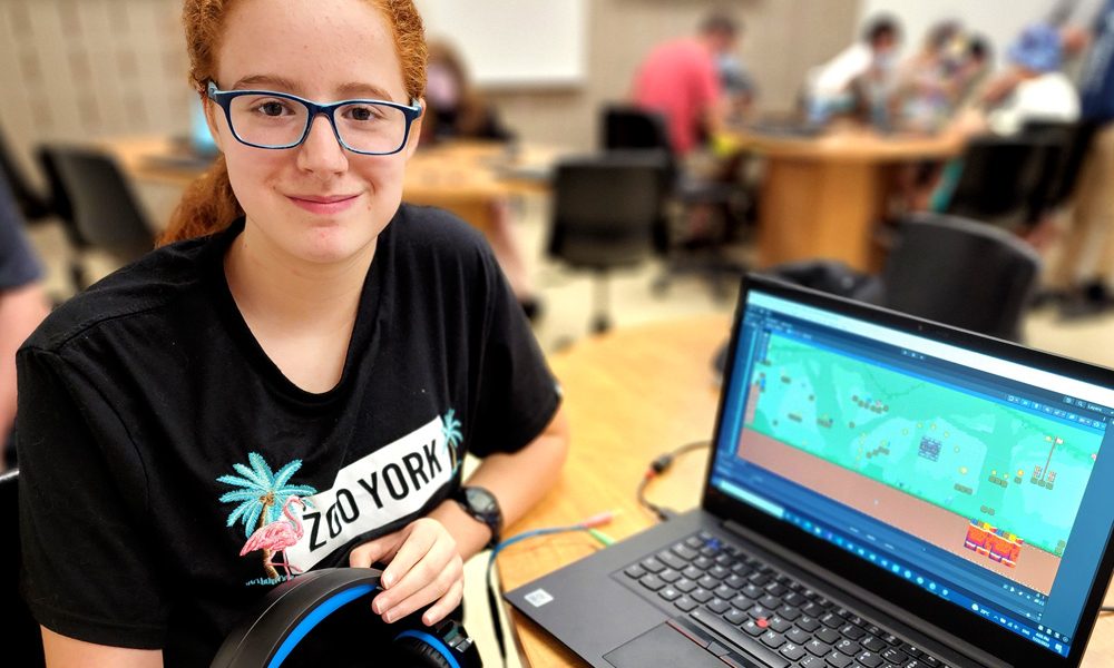 Une jeune présentant son jeu vidéo via son ordinateur